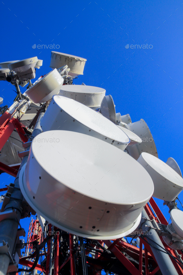 Closeup Of Microwave Dish On High Antenna Tower And Blue Sky