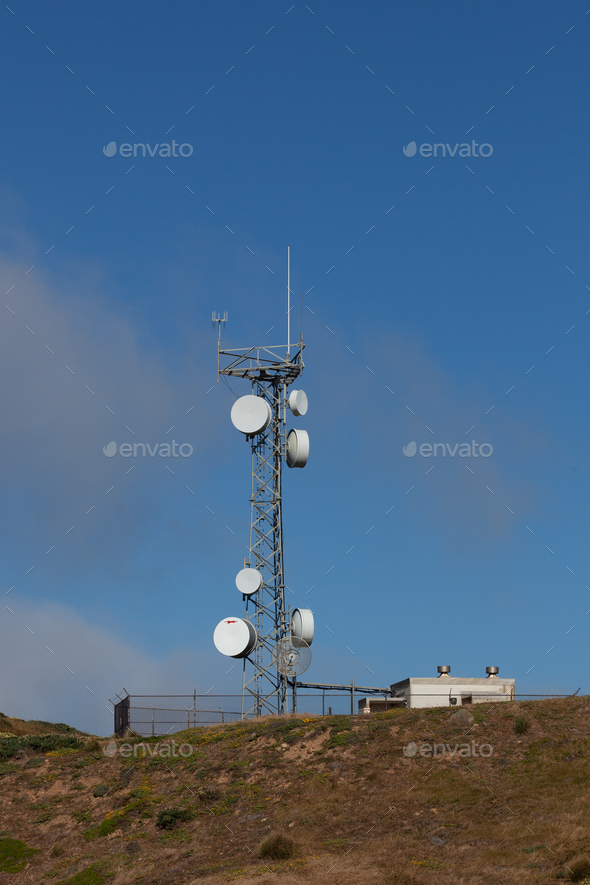 Vertical shot of a microwave relay telecom radio antennas on a mountain top tower during daylight