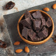 Dark natural chocolate in large pieces in a wooden bowl. Artisan chocolate. - PhotoDune Item for Sale