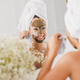 Woman In Front Of Mirror Removing Facial Mask At The Beauty Salon - PhotoDune Item for Sale