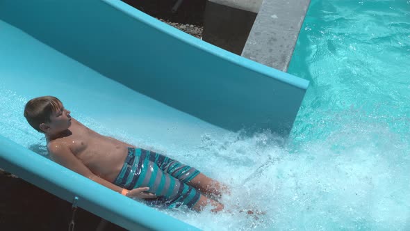 Boy going down waterslide in super slow motion