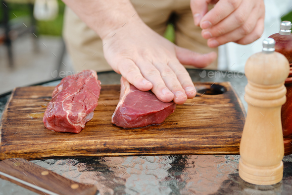 Rubbing olive oil over raw strip steak