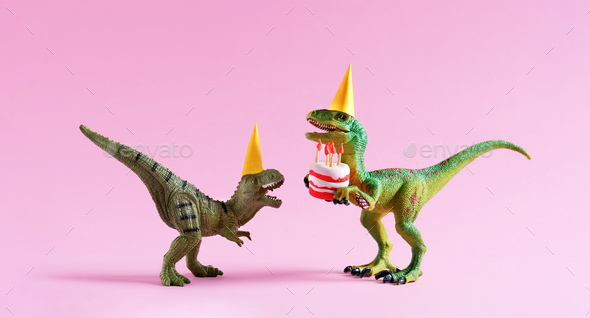 Cute happy green dinosaurs in birthday hats holding cake with flaming candles