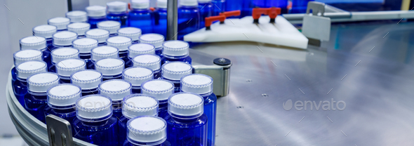 plastic bottle on conveyor belt at filling machine in medical factory. pharmaceutical manufacturing.