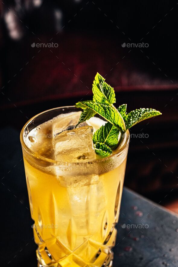 Zombie cocktail with a mint decoration isolated in the bar\'s background