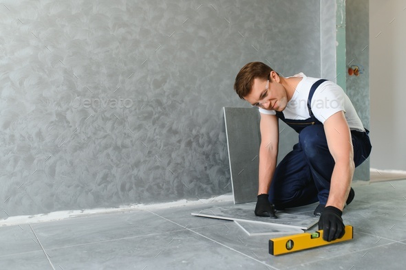 industrial worker, handyman installing ceramic tiles.