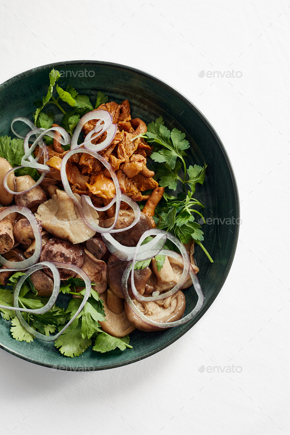 mushrooms in a green bowl. Chopped onions and mushrooms. White background. Top view. Copy space