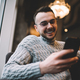 Cheerful man drinking coffee while browsing smartphone - PhotoDune Item for Sale