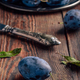 Ripe plums with leaves and knife - PhotoDune Item for Sale