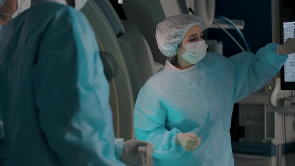 Three Serious Professional Surgeons Preparing for a Complex Operation alt