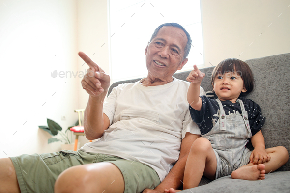 grandpa watching tv with his grandchild