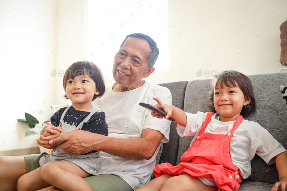 grandpa watching tv with his grandchildren