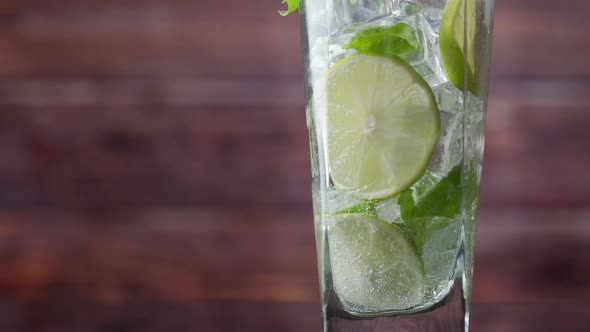 Close-up Refreshing Soda Tonic, Pour Carbonated Water Into a Glass of Lime and Ice, Cold Mojito alt