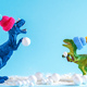 Two cute dinosaurs in knitted hats build snowman. Cute funny winter holidays creative poster. - PhotoDune Item for Sale