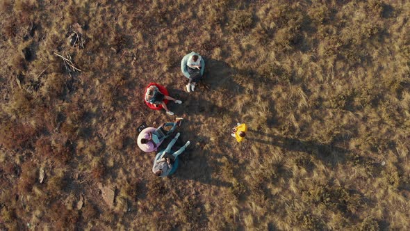 Friendly Group of Freelancers Discuss an Important Project While Sitting on Bag Chairs in Aerial alt