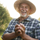 Portrait of senior farmer holding an apple in hand - PhotoDune Item for Sale