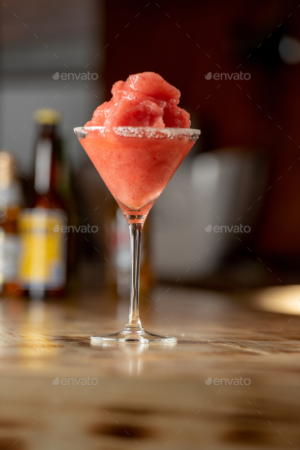 Vertical shot of a frozen margarita cocktail in a bar