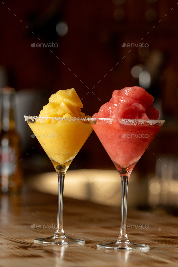 Vertical shot of frozen margarita cocktails in a bar