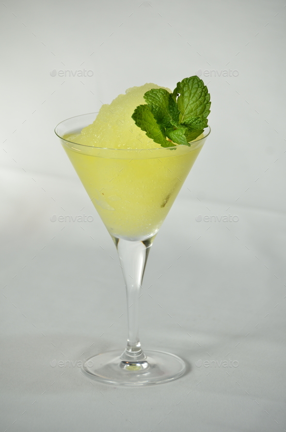 Close-up shot of frozen Margarita cocktail with mint on a white background