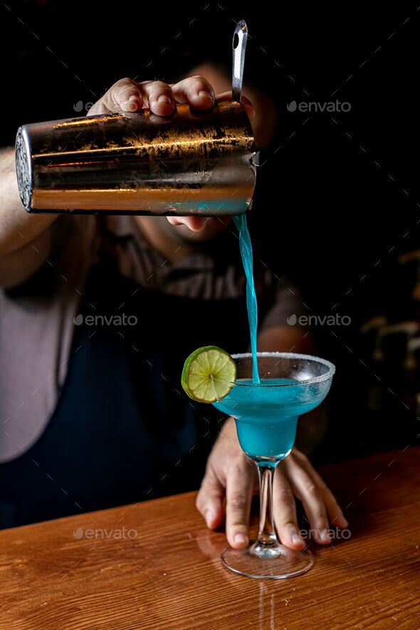 Bartender making a blue margarita using a cocktail shaker Stock Photo