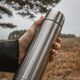 Vertical closeup shot of a person holding a stainless steel coffee thermos - PhotoDune Item for Sale