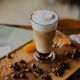 Close-up of a layered latte in a tall glass on a wooden board in a cafe - PhotoDune Item for Sale