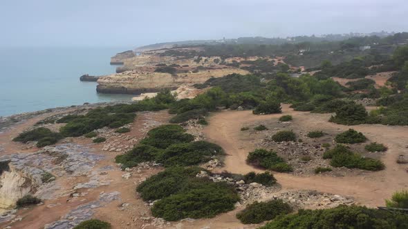Fontainhas Beach Cliffs in South Portugal seen from the side, Aerial dolly in reveal shot alt
