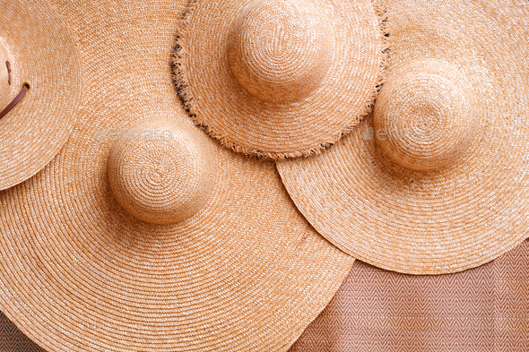 Wicker products background of 4 straw floppy hats on woven mat, Top view with copy space