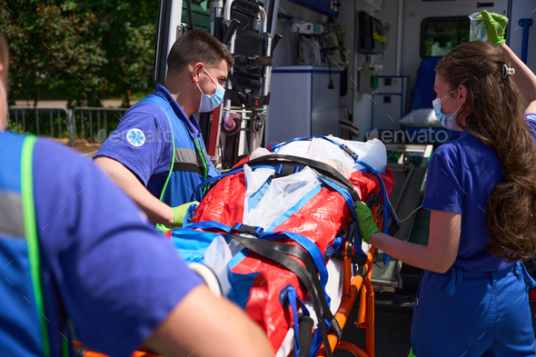 Ambulance team transports the patient on special stretcher to ambulance