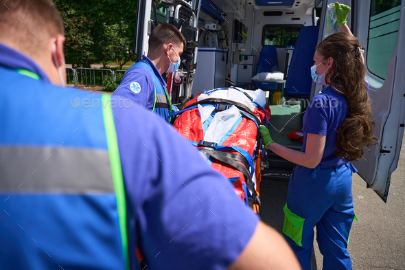 Paramedics transport the patient on a special stretcher to ambulance