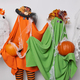 Photo of two creepy orange and green creatures pose orange pumpkins surrounded by ghosts try to be - PhotoDune Item for Sale