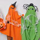 Horizontal shot of two orange and green ghosts pose with carved orange pumpkin and spider net stand - PhotoDune Item for Sale
