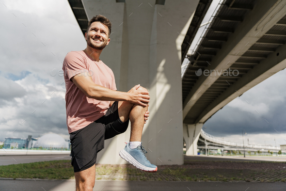 A trainer in fitness clothes is a T-shirt, running sports shoes and a  fitness watch. Stock Photo by denismuse777