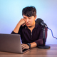 Upset asian man looking at the laptop in the studio with microphone - PhotoDune Item for Sale