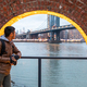 Man standing near brick arch and looking at the Manhattan bridge - PhotoDune Item for Sale