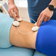 Male rehabilitation specialist putting sensors at female spine - PhotoDune Item for Sale