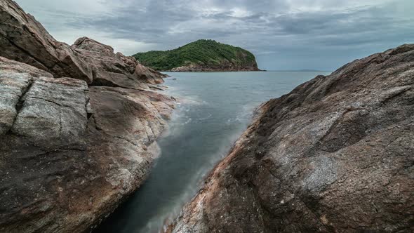 Dramatic rocky coastline at dusk and smooth sea wave alt