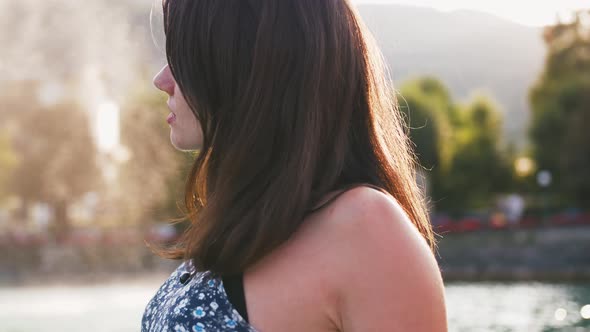 Portrait of Young Woman in Dress Sitting at the Edge of Wooden Pier at Lake in Mountains Enjoying alt