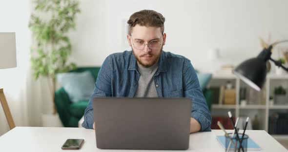 Man Coding on Laptop at Home
