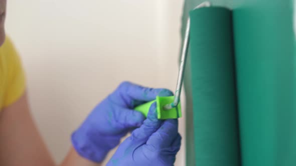 Repair of the Apartment - Professional Painter Paints the Walls with Green Paint Roller