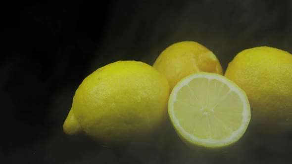 Tropical Fruit Lemon in Cold Ice Clouds of Fog Smoke on Black Background alt