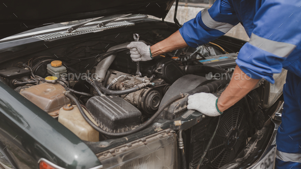 Car mechanic is inspecting the engine of a car coming in for repair at the center. Professional engi - Stock Photo - Images