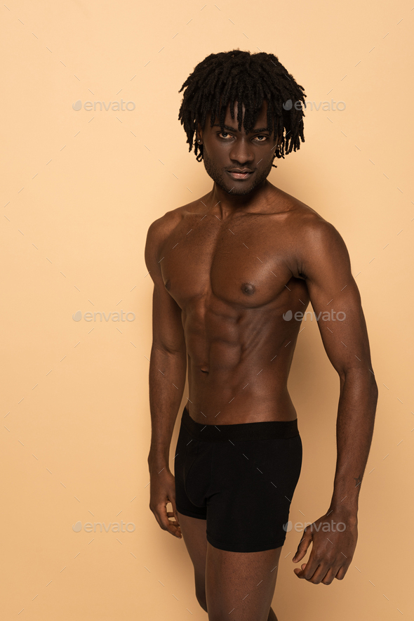 seductive shirtless african american man on beige - Stock Photo - Images