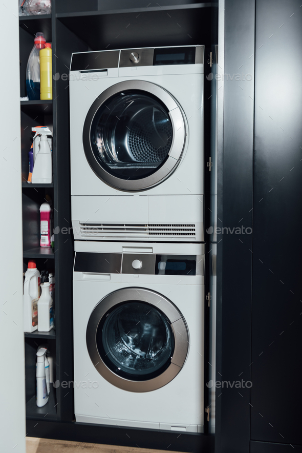 cropped view of man holding measuring cup with blue detergent near washing  machine with dirty Stock Photo by LightFieldStudios