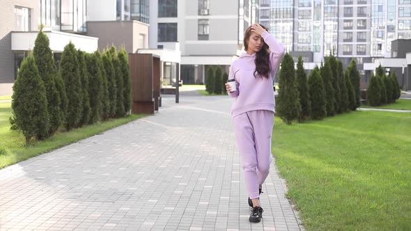 Confident Beautiful Girl in Lilac Hoodie with Coffee