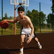 Active teenager basketball player practicing with ball on street court - PhotoDune Item for Sale