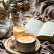 Home still life with a candle and a book in bed. - PhotoDune Item for Sale