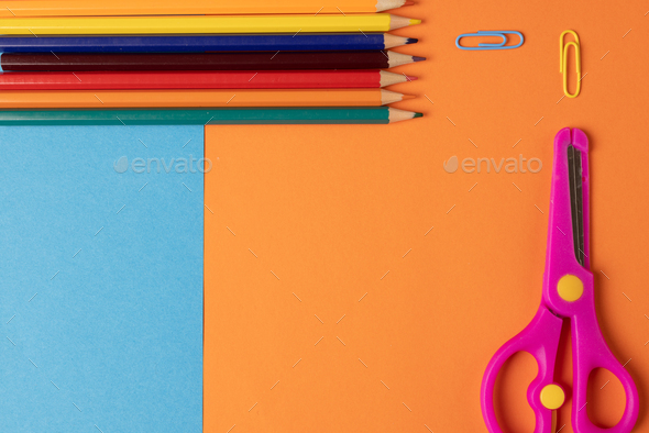 Vertical composition of post its, eraser, crayons and scissors on blue  surface with copy space Stock Photo by Wavebreakmedia