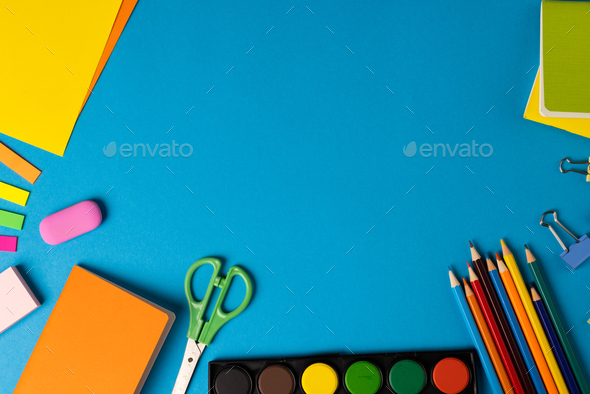 Vertical composition of post its, eraser, crayons and scissors on blue  surface with copy space Stock Photo by Wavebreakmedia