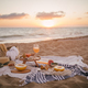 Beautiful tasty picnic with lemonade, fresh fruits and croissants on a beach at sunset. - PhotoDune Item for Sale